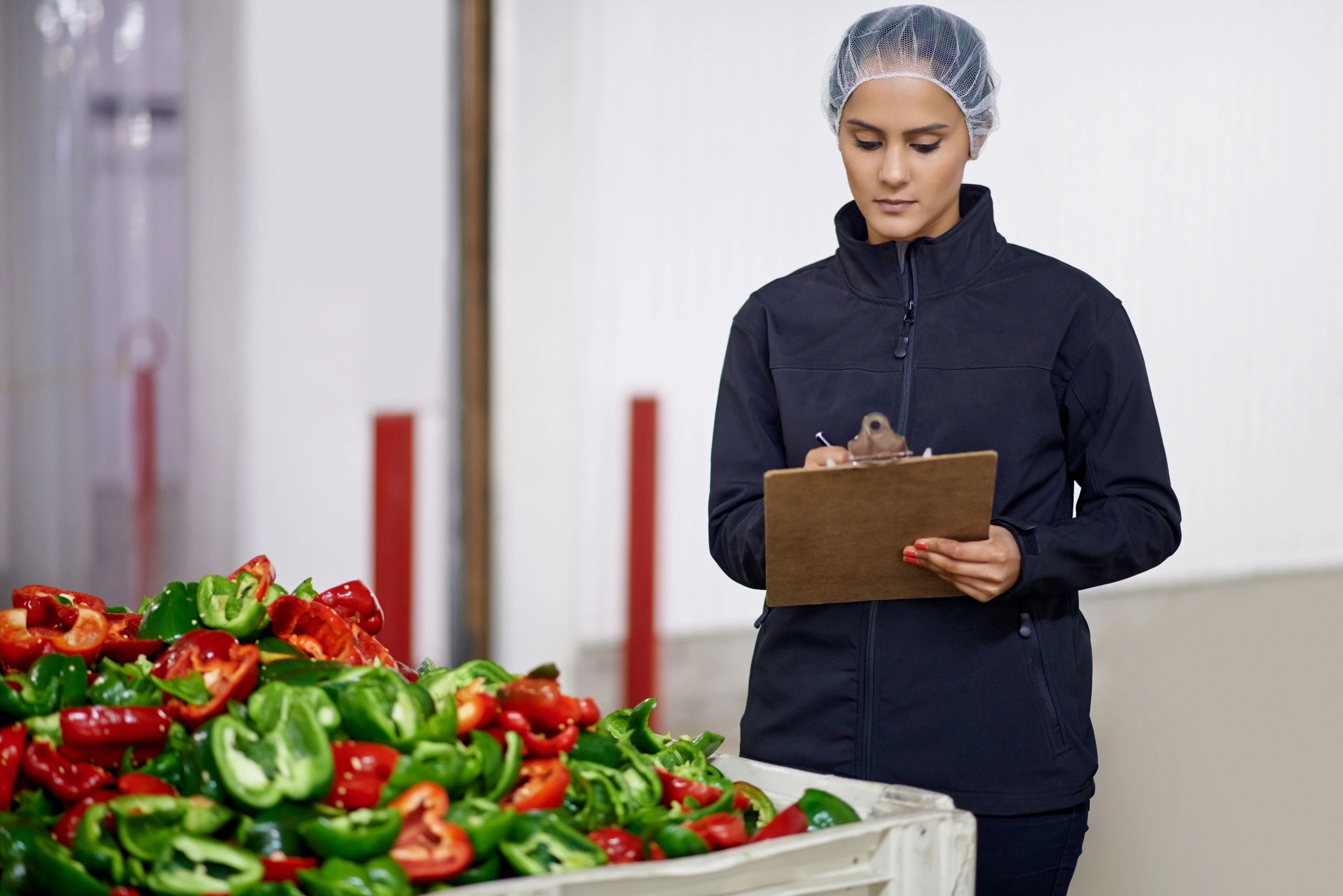 Quality control worker monitoring peppers on a conveyor
