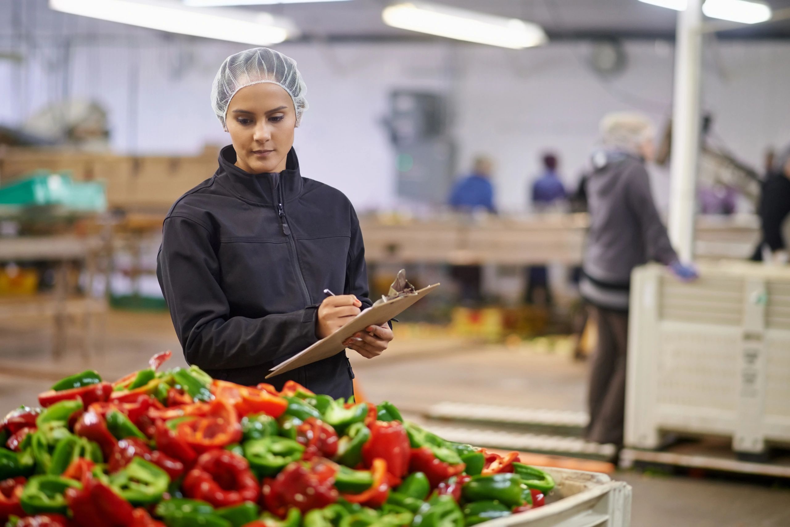 Quality control worker inspecting produce in a processing facility